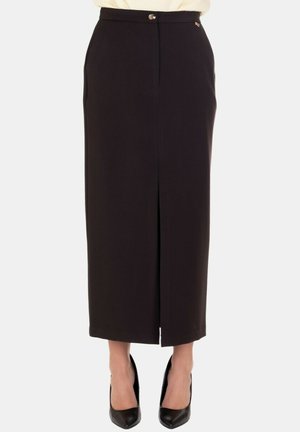 Gonna nera a matita con spacco frontale, design sartoriale, chiusura con bottone e tasche laterali, realizzata in tessuto liscio. Abbinata a tacchi neri.