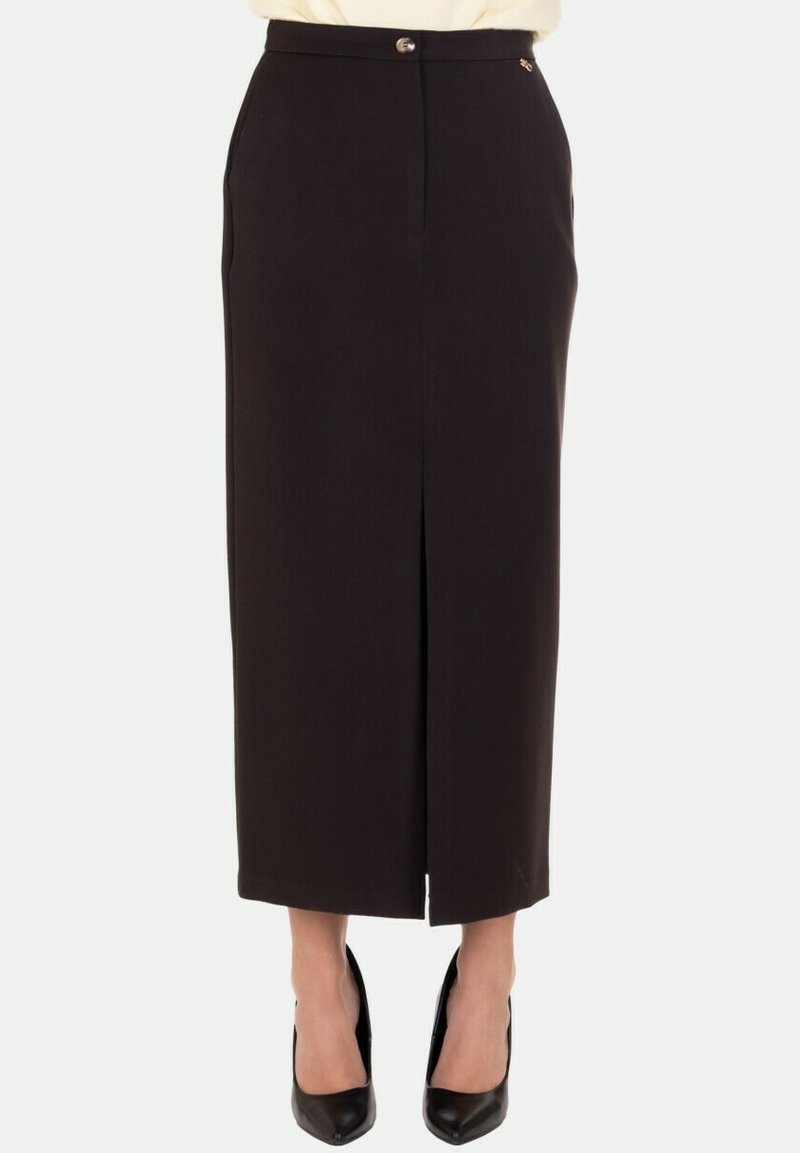 Gonna nera a matita con spacco frontale, design sartoriale, chiusura con bottone e tasche laterali, realizzata in tessuto liscio. Abbinata a tacchi neri.