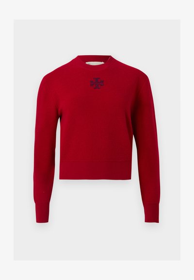 Pull rouge à manches longues avec col rond, poignets et ourlet côtelés, arborant un petit logo sombre centré sous l'encolure.