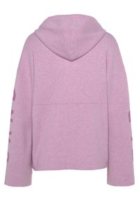 Felpa cappuccio rosa chiaro con vestibilità rilassata. Caratterizzata da una cucitura centrale e testo in un rosa più scuro sulla manica sinistra. Tessuto morbido.