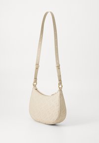 Bežna torba iz umetne usnje s utisnjenim logotipom, ukrivljene oblike, zlato-toniranimi dodatki in prilagodljivim trakom s perforacijami.