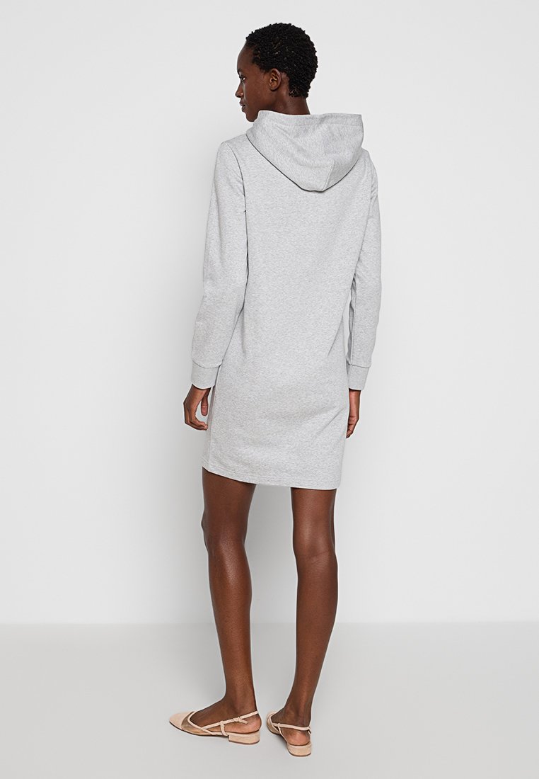 Vestido sudadera gris con mangas largas, textura suave y corte holgado, con capucha y que llega a la mitad del muslo.