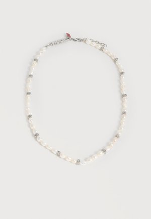 Κολιέ με λευκά ακανόνιστα μαργαριτάρια, διαχωρισμένα με μικρούς ασημένιους κρίκους, που διαθέτει ασημένια κούμπωμα και μικρή κόκκινη ετικέτα κοντά στο κούμπωμα.