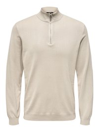 Beiger Pullover mit langen Ärmeln, hohem Kragen und halbem Reißverschluss. Hergestellt aus einem glatten, leichten Strickstoff.