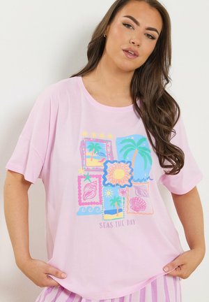 Mujer con camiseta rosa con estampados coloridos de temática playera que incluyen palmeras, conchas marinas, sol y la frase "Aprovecha el día".