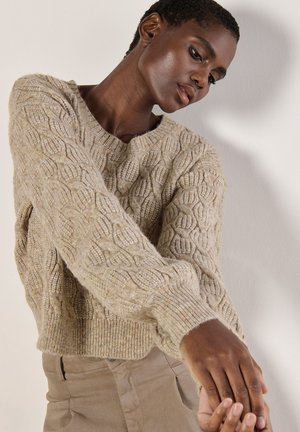 Light beige cable-knit sweater with a round neckline and ribbed cuffs, featuring a textured pattern and a cropped silhouette.