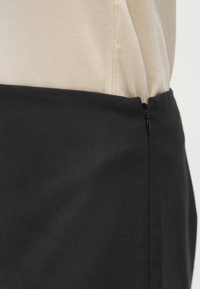 Melns svārks ar gludu faktūru un krēmkrāsas augšdaļu. Aprīkots ar sānu rāvējslēdzēja aizdari un tīru, strukturētu dizainu.