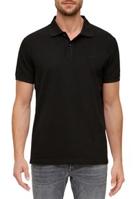 Zwarte polo met een klassieke kraag, korte mouwen en een subtiele textuur. Voorzien van een klein logo op de linkerborst.
