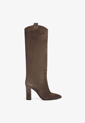 Stivale in suede marrone sopra il ginocchio con punta affilata, tacco a blocco e un design minimalista caratterizzato da una sottile linguetta posteriore.