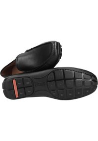 Sorte læder loafers med en glat finish, rund tå, gummisål med grebsmønster og røde detaljer på hælen.