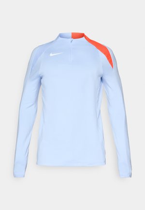 Haut de sport à manches longues bleu clair avec zip quart, présentant des accents orange sur l'épaule et un petit logo Nike blanc sur la poitrine.