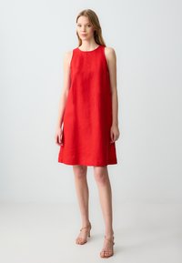 Rotes Leinen-Kleid ohne Ärmel mit rundem Halsausschnitt, lässigem Schnitt und knielangem Saum. Glatte Textur, keine Muster oder Verzierungen.