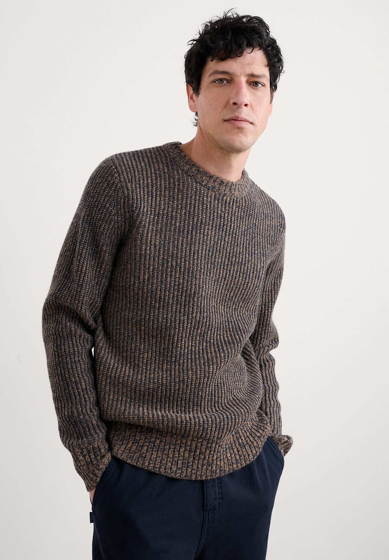 Brązowy sweter z prążkowanej dzianiny z okrągłym dekoltem, o fakturowanej powierzchni. Krój jest luźny, z długimi rękawami i prostym dołem.