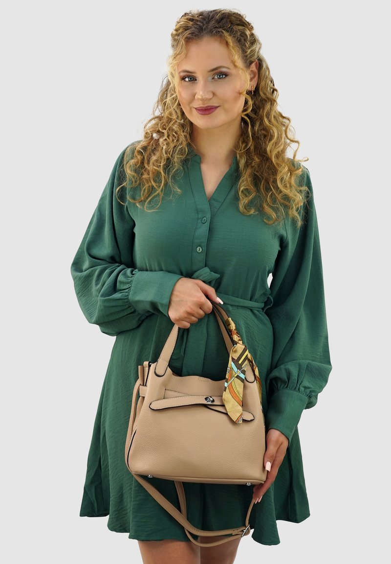 Beige leren handtas met dubbele handgrepen, een verwijderbaar sjaalaccent en een veilige bovenklep. De textuur is gekorreld en heeft hardware in zilverkleur.