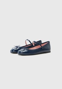 Meripihkan balet kulit paten navy dengan ujung bulat, tali yang dapat disesuaikan, dan aksen pita di bagian depan. Bagian dalam dilapisi dengan kain berwarna merah muda.