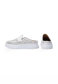 Weiße Slipper mit perfoziertem Muster, flexibem Obermaterial, flacher Sohle und gepolstertem Kragen. Minimalistisches Design ohne sichtbare Akzente.