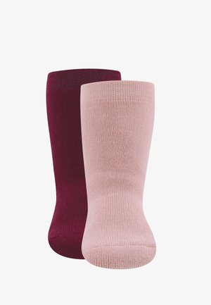 Zwei Paar kniehohe Socken: ein Paar in tiefem Burgunderrot und das andere in hellrosa. Beide sind mit gerippten Mustern strukturiert.