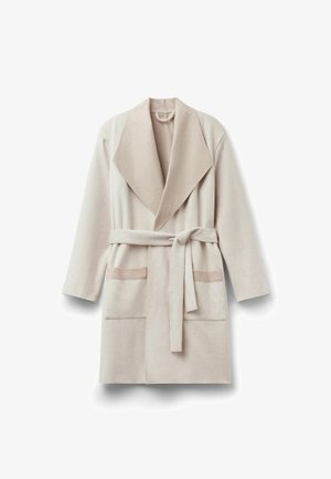 Beige badrock med stor sjalkrage, bälte i midjan, långa ärmar och två framfickor med kontrasterande tyg vid fickkanterna.