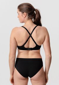 Bikini noir avec un design à dos croisé. Le haut dispose de bretelles ajustables et d'une fermeture à crochet. Le bas est taille haute avec une texture lisse.