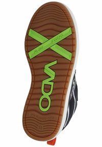 Sola di una scarpa con una base in gomma marrone a motivo, accenti verdi contrassegnati con "FLEX ZONE" e una tomaia in tessuto nero con strisce bianche.