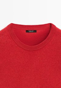 Rode trui met ronde hals van gebreide stof en geribbelde kraag, met een zwart label binnenin de hals met de tekst "Massimo Dutti Made in China."