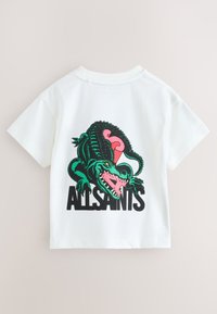 Biała bawełniana koszulka z grafiką zielonego krokodyla z różowymi akcentami oraz czarnym napisem "ALLSAINTS" na dole. Krótkie rękawy, okrągły dekolt.