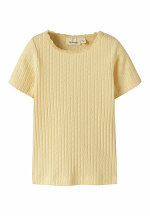 Krótki rękaw bluzka z jasnżółtej dzianiny z teksturowanymi pionowymi paskami i małymi ażurowymi wzorami, z wykończeniem dekoltu w kształcie fali.