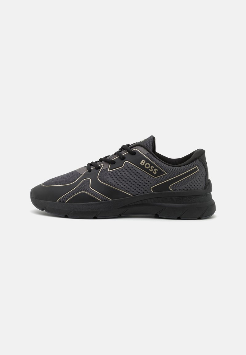 Baskets de sport noir et gris foncé avec panneaux en mesh et synthétiques, lacets noirs, et logo BOSS sur le côté.