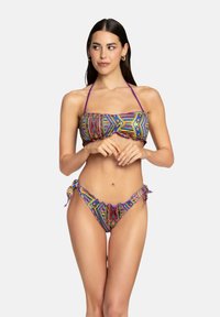 Bikini multicolore con top a bandeau a fantasia, caratterizzato da spalline viola, e slip a vita bassa con legacci laterali, progettato per un aspetto vivace.