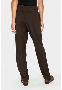 Braune Hose mit entspannter Passform, elastischem Bund und glattem Stoff. Das Design verfügt über gerade Beine und minimale Details.