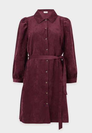 Abito in corduroy bordeaux con collo a camicia, maniche lunghe a sbuffo, chiusura con bottoni sul davanti e una cintura abbinata in vita.