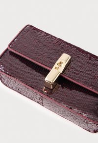 Bourgognefarvet palietbelagt clutch med en glat tekstur, gyldent hardware-lukning og en rektangulær form. Kanter er markeret med en tynd, matchende kant.