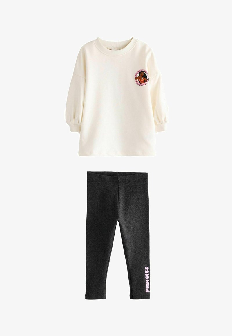 Krems krāsas džemperis ar puffed piedurknēm, kuram ir rozā grafika. Melnas legingi ar maigu tekstūru un rozā tekstu "PRINCESS" sānos.