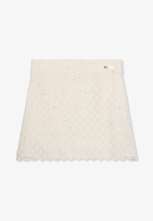 Una gonna bianca in pizzo con un motivo floreale, adornata da sottili paillettes, con un orlo scallop e un piccolo tag metallico vicino alla vita.