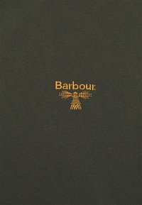 Tissu vert foncé avec petit logo orange "Barbour" et emblème de phare brodés au centre.