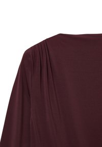 Blusa bordeaux realizzata in tessuto morbido e fluido, con pieghe sottili lungo la cucitura della spalla e un ampio scollo. Texture liscia.