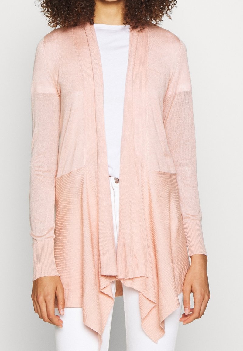Světle růžový pletený kardigan s volně splývající přední částí, dlouhými rukávy a ribbíkovými akcenty. Obsahuje pohodlný střih a kaskádový lem.