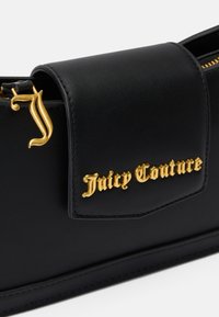 Fekete bőr kézitáska arany "Juicy Couture" logóval és arany díszítéssel a fedele záródásán. Simára csiszolt felülettel és elegáns kialakítással.