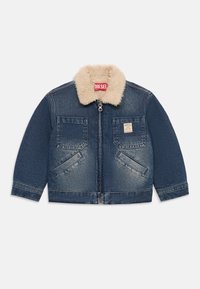 Casaco de ganga azul com gola de pelúcia sintética, fecho de zíper, dois bolsos no peito e bolsos laterais em ângulo. Apresenta uma etiqueta no bolso esquerdo.