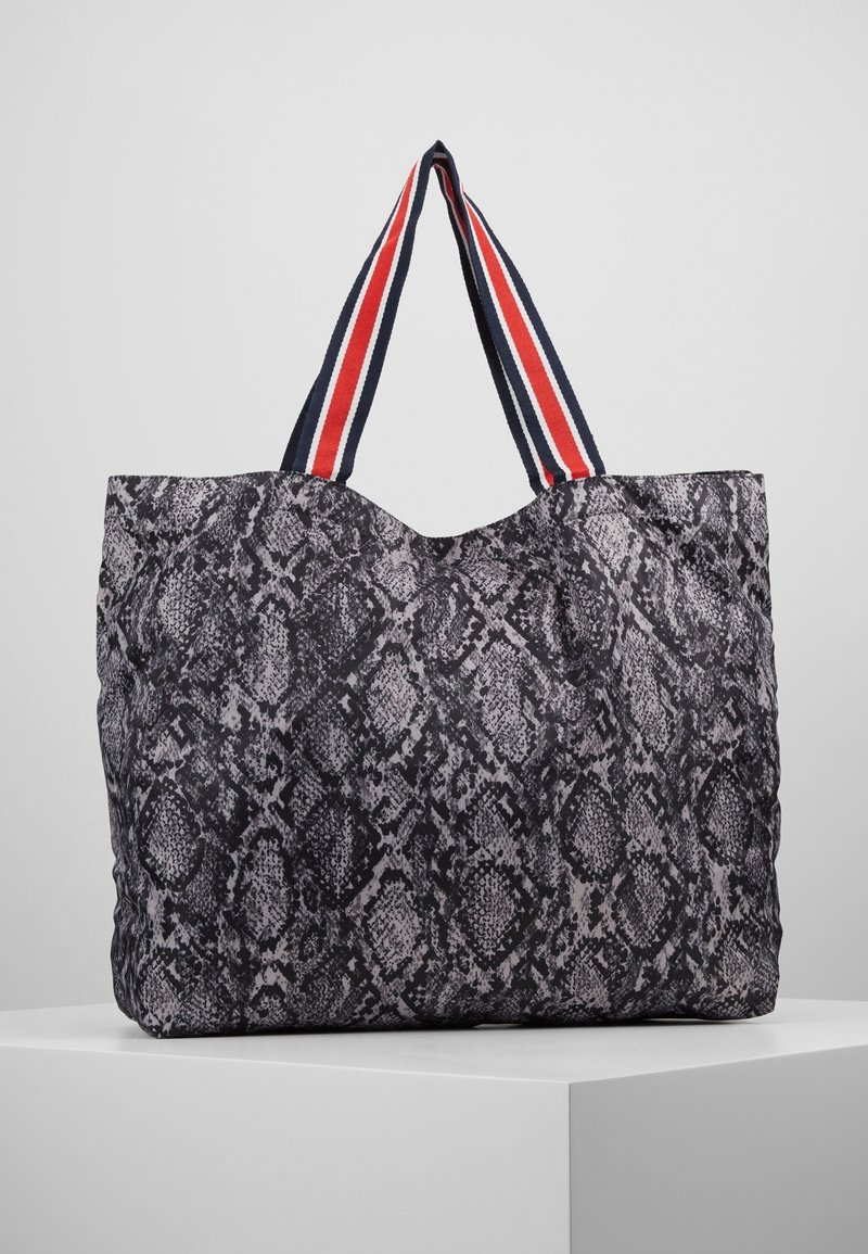Grote tote bag met zwart en grijs slangprint, met stoffen handvatten in rood en marineblauw gestreept. Zachte textuur en slouchy vorm.