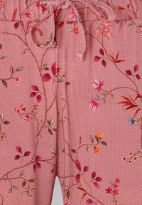 Pink fabric with small polka dots and embroidered floral vines in red, pink, orange, green, and blue, featuring a tied drawstring waist.