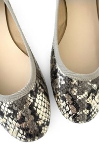 Chaussures plates en motif faux serpent avec des accents gris, bout rond et bord élastique pour un ajustement sûr. Texture lisse et brillante.