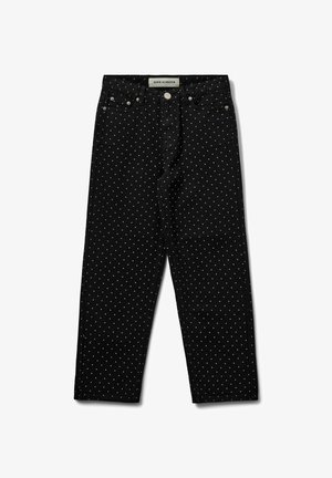 Jeans en denim noir à pois blancs, avec une coupe droite, des poches avant et des éléments en métal au niveau de la taille et de la braguette.