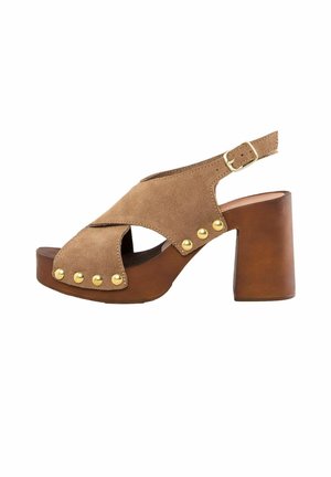 Braune Wildleder-Peeptoe-Sandale mit einem Kreuzriemen-Design, goldenen Nieten und einem verstellbaren Knöchelriemen. Klobiger Absatz mit Holzoptik.