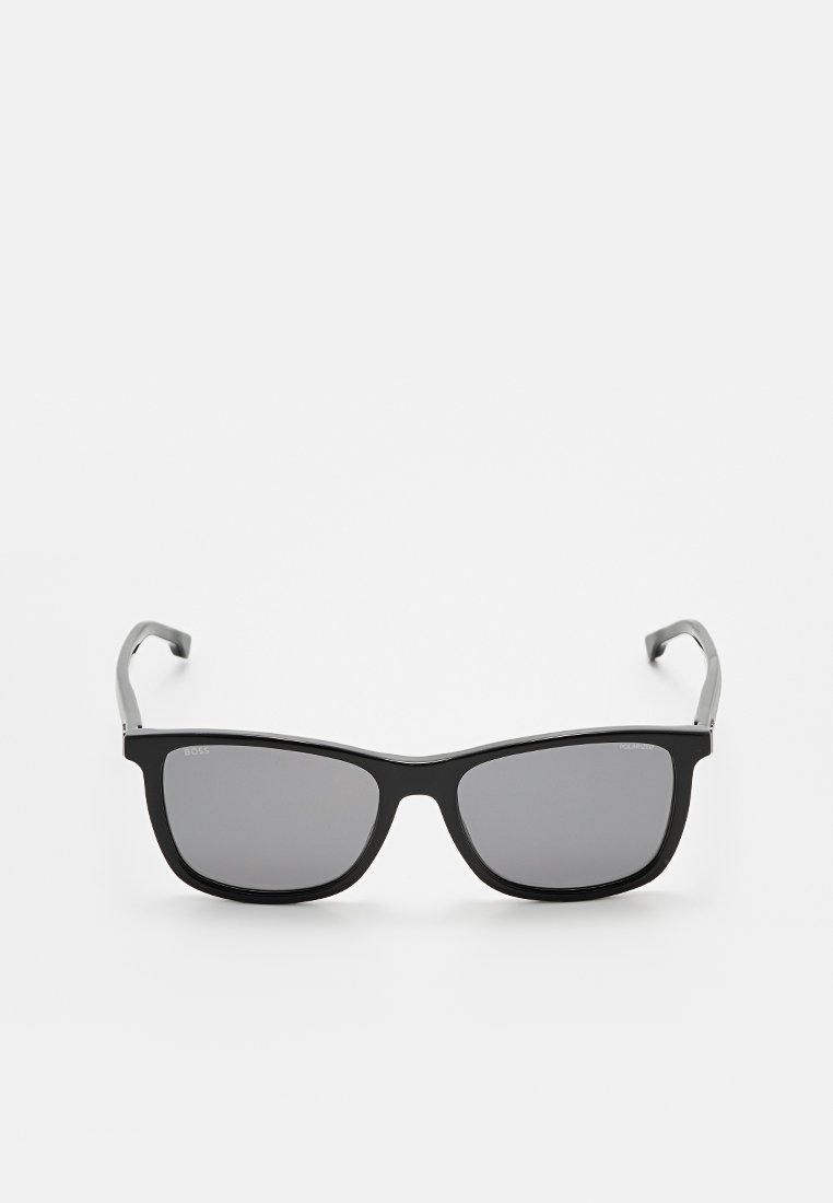 Schwarze Sonnenbrille mit rechteckigem Rahmen, grauen Gläsern und schlanken Bügeln. Der Rahmen hat eine glänzende Oberfläche und minimalistische Branding.