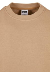 Felpa beige con colletto a girocollo a costine. Realizzata in tessuto morbido, presenta una superficie texturizzata uniforme e senza motivi visibili.
