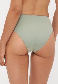 Hoge taille groene bikinibottom gemaakt van soepel materiaal, met een elastische tailleband en naadloze afwerking voor comfort.