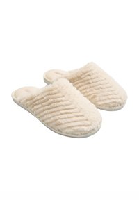 Zapatillas beige difusas con textura acanalada, parte trasera abierta y una parte superior suave y acolchada. Suela de goma blanca que proporciona agarre y soporte.