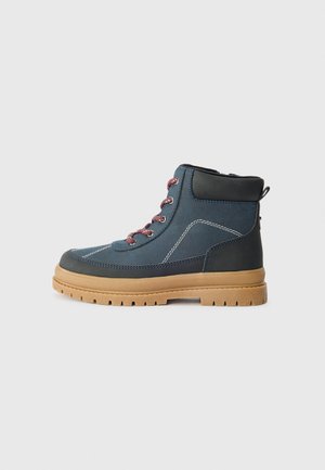 Bottine en nylon bleu et cuir avec des lacets roses, semelle en caoutchouc, couture contrastée et une languette à l'arrière.