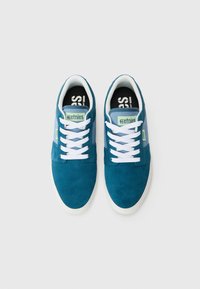 Teal suede sneakers with a white rubber sole, light blue accents, and white laces. Etnies logo on tongue and side panel.